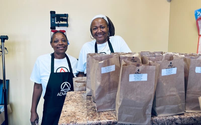 Two volunteers with bagged meals at an Advance Church food outreach