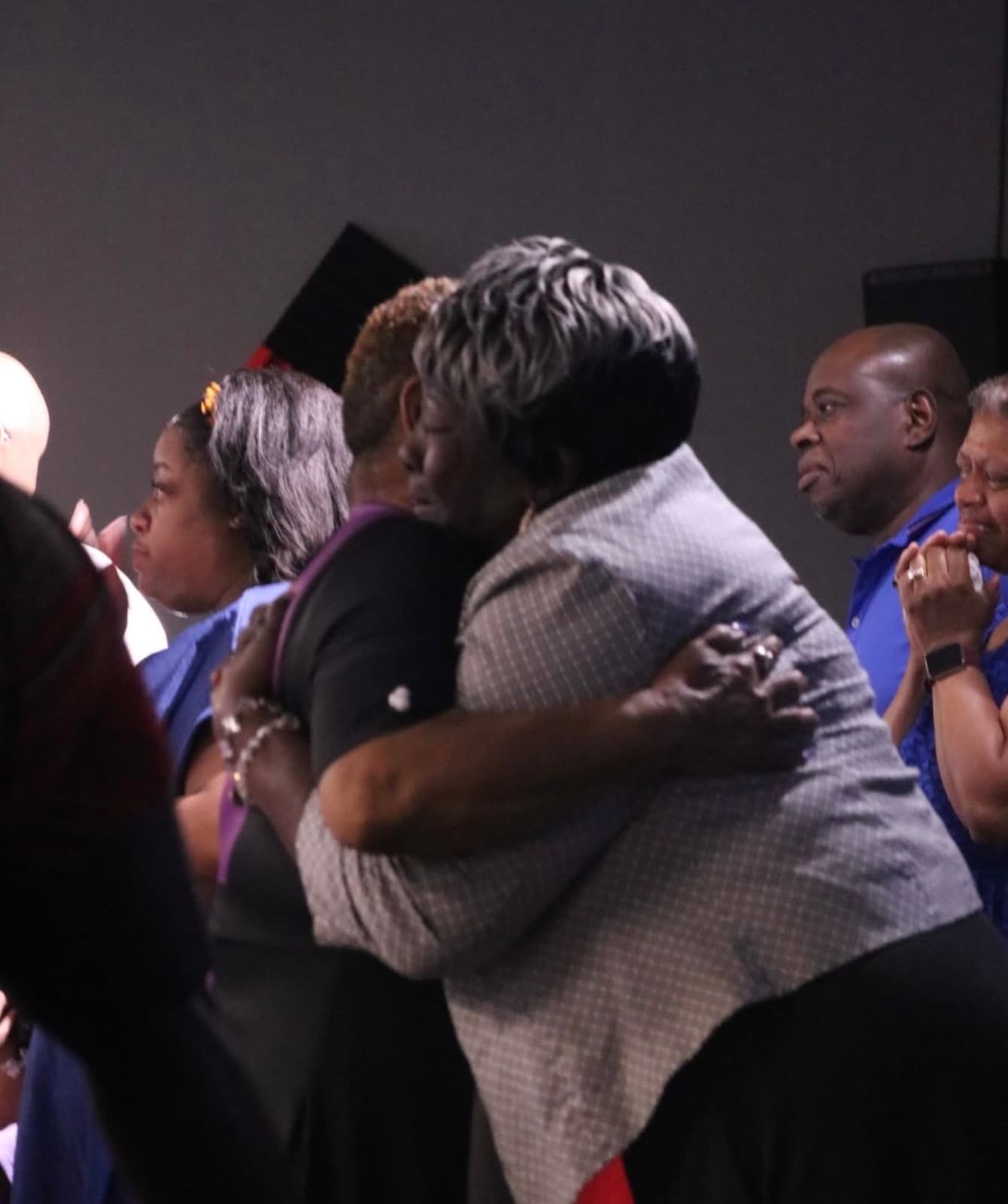Two members of Advance Church embracing during a service
