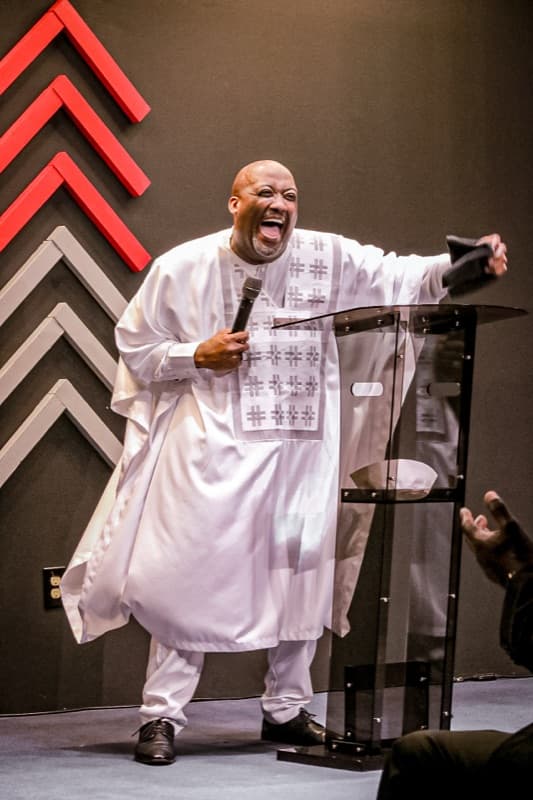 A preacher celebrating at the podium during a service at Advance Church